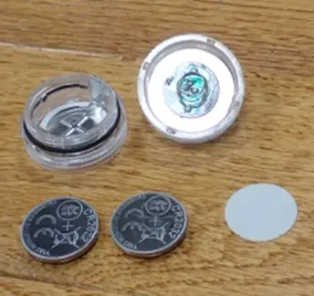 Recalled JINHEZO Mini Waterproof LED Tea Light opened to show accessible button cell batteries