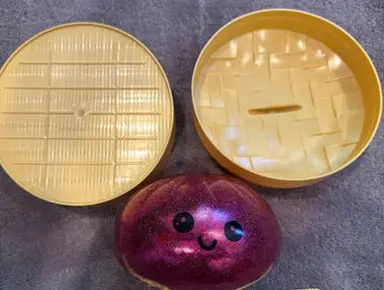 Recalled Mochi Malrang Mystery Dumpling Toy and tan plastic container