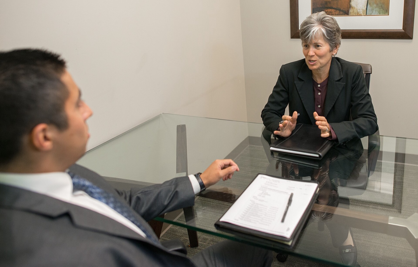 Two people reviewing an offer letter at a bright office table