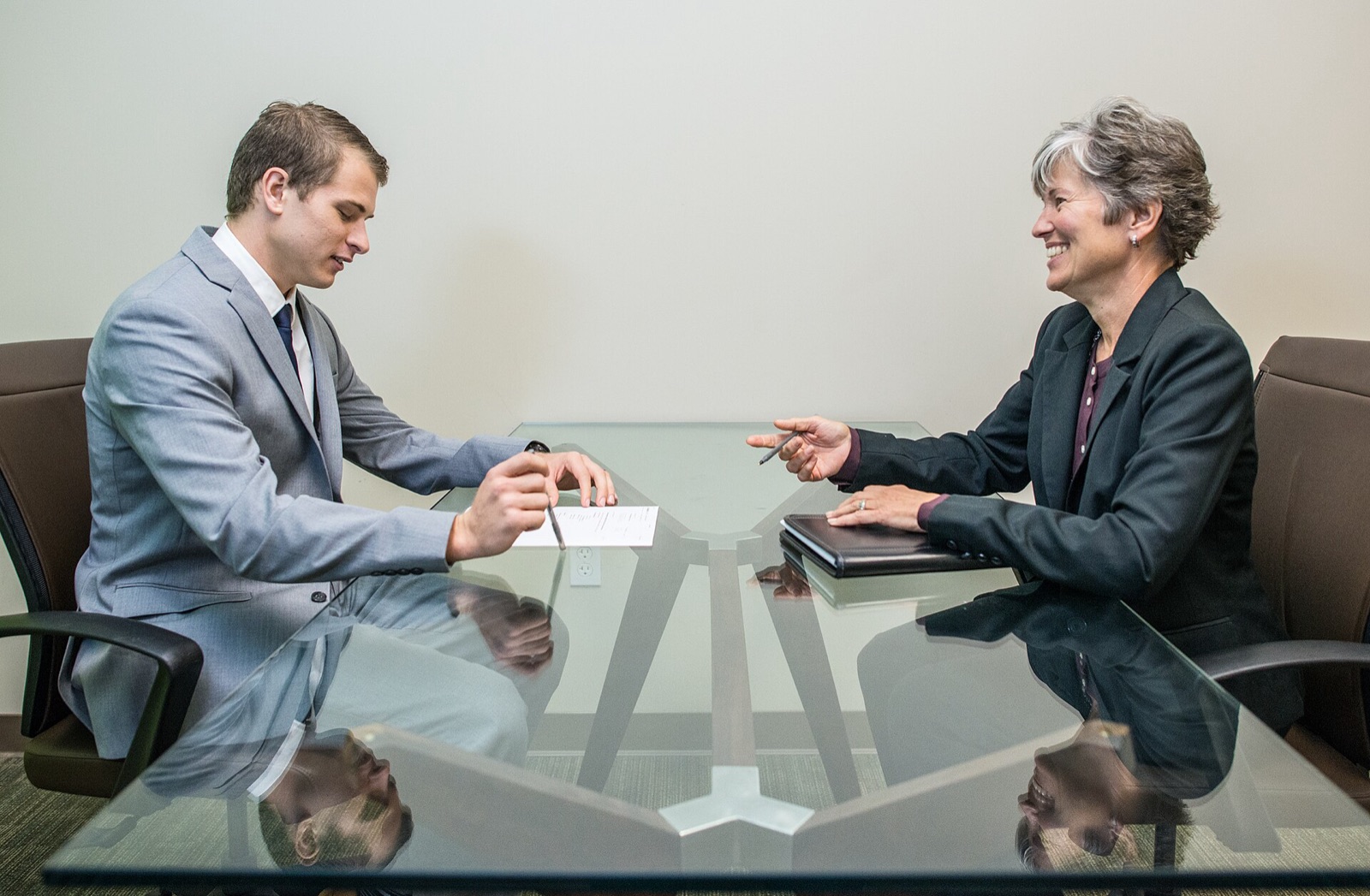 A candidate speaking across a desk in a bright office during a job interview