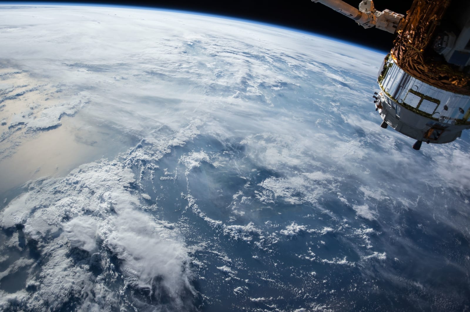 A communications satellite above Earth with its solar panels extended